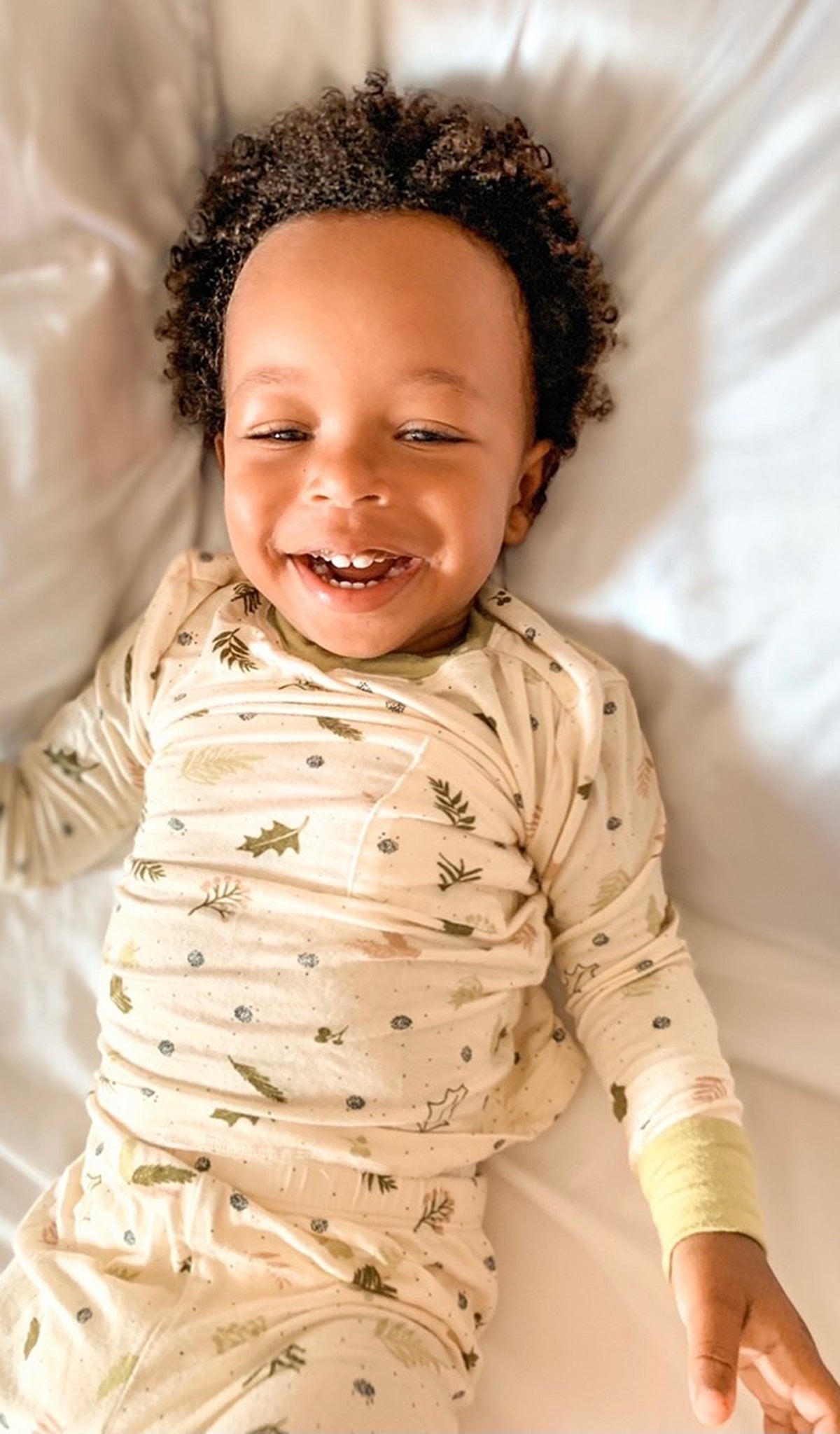 Nature Emerson Baby 2-Piece Pant PJ. Lifestyle shot of smiling boy laying down on back wearing Emerson.